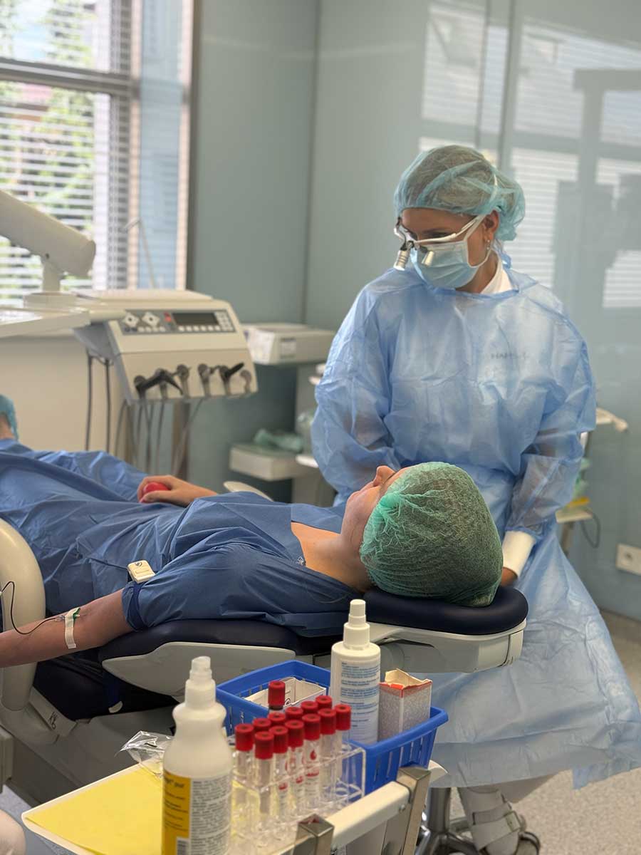 Lekarka przy pacjencie w fotelu, przygotowanie probówek do zabiegu