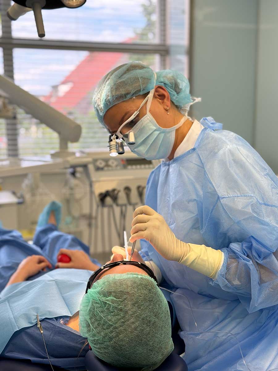 Lekarka w lupach podczas precyzyjnego zabiegu stomatologicznego