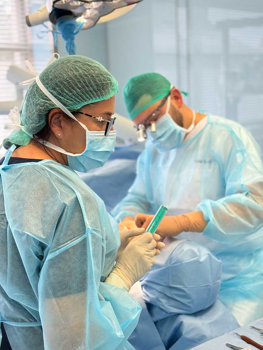 Asysta przygotowuje materiał podczas zabiegu implantologicznego