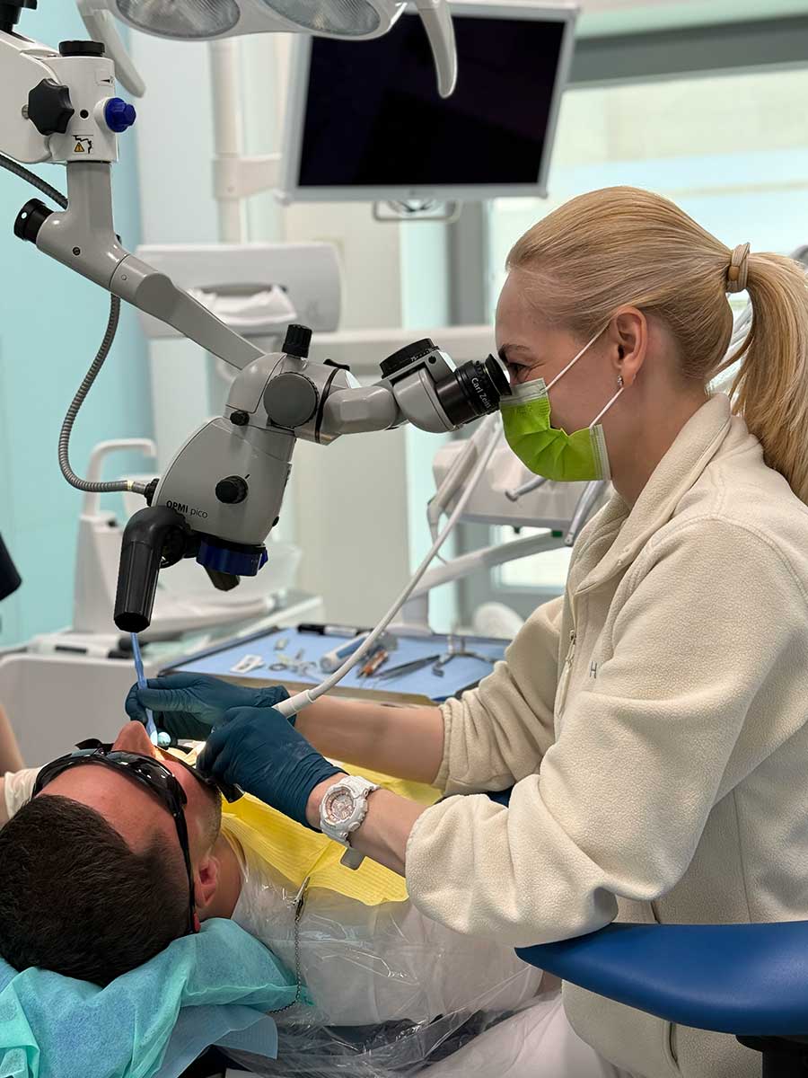 Praca pod mikroskopem podczas leczenia kanałowego zęba