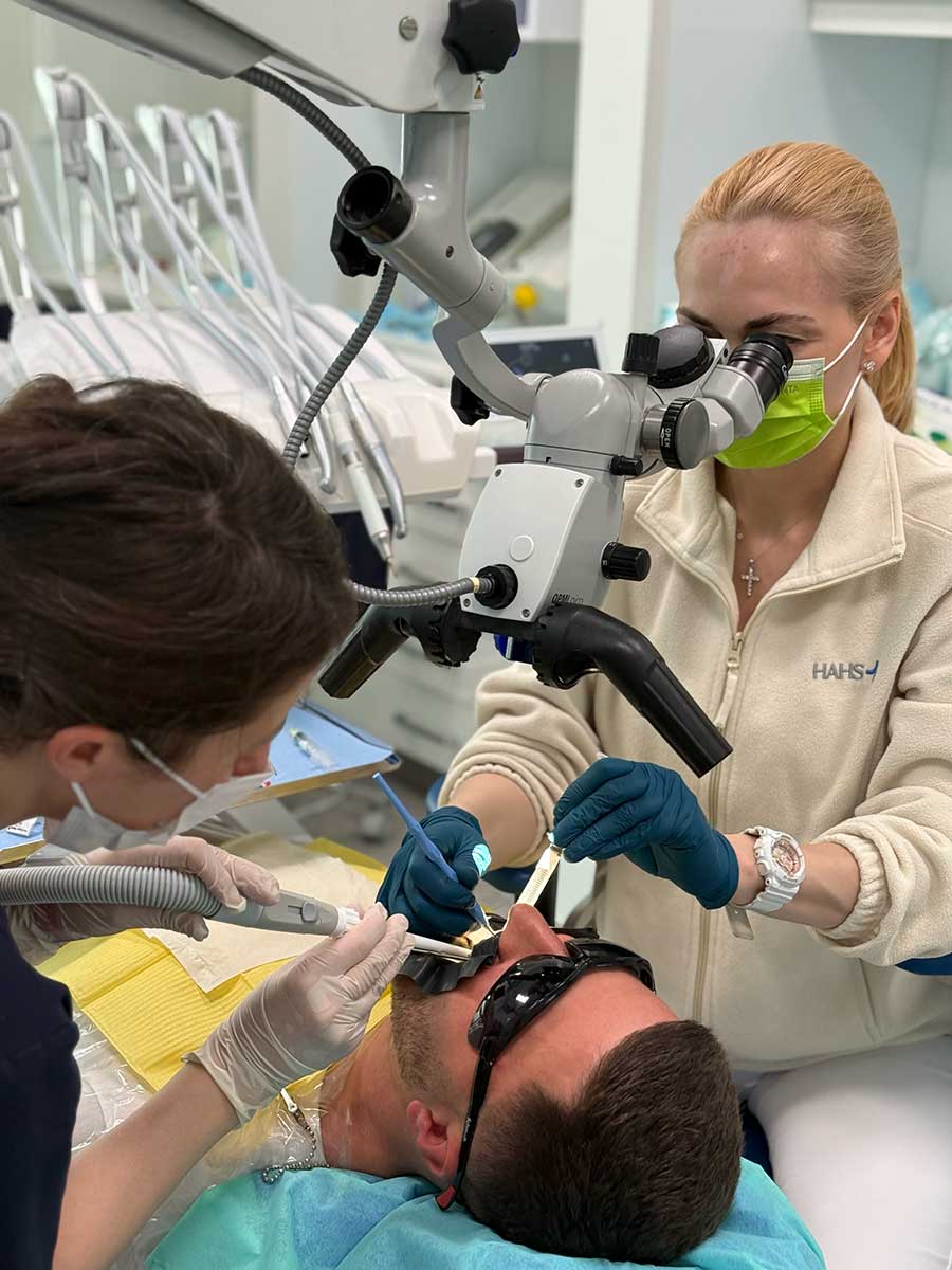 Praca zespołowa lekarki i asystentki podczas zabiegu endodontycznego
